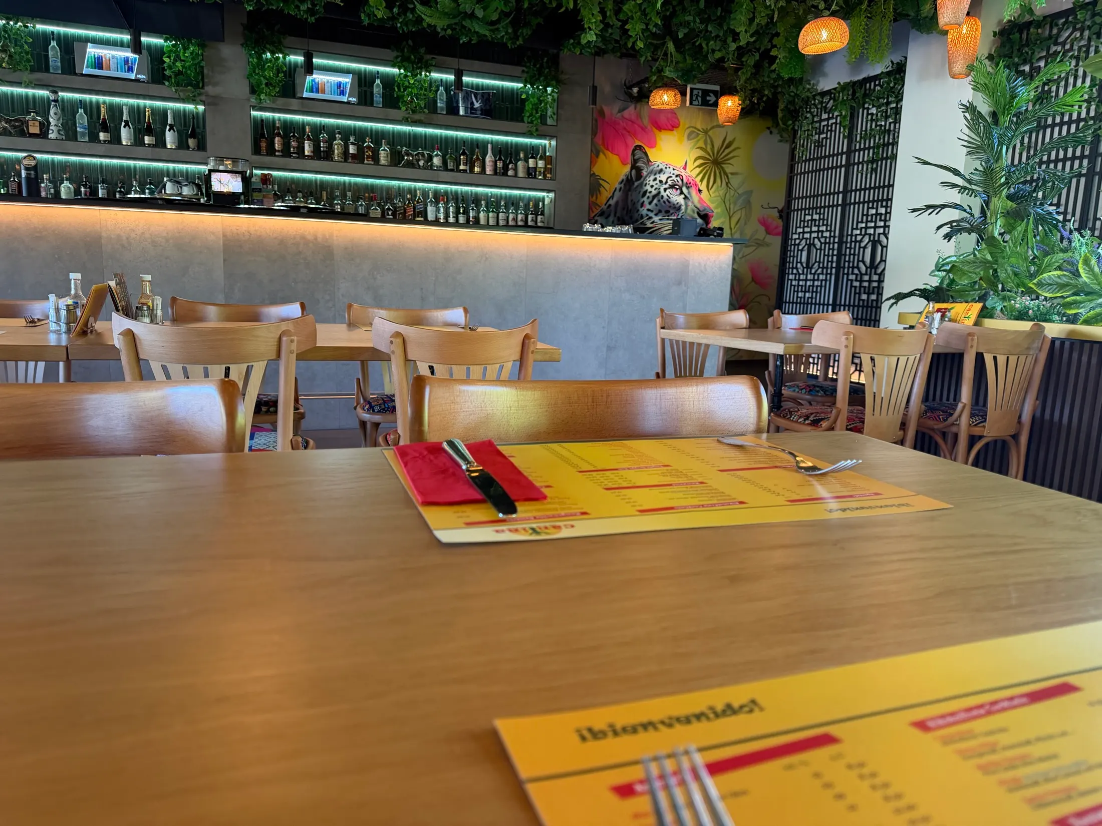 Ein gedeckter Tisch mit der Speisekarte, dahinter die Bar